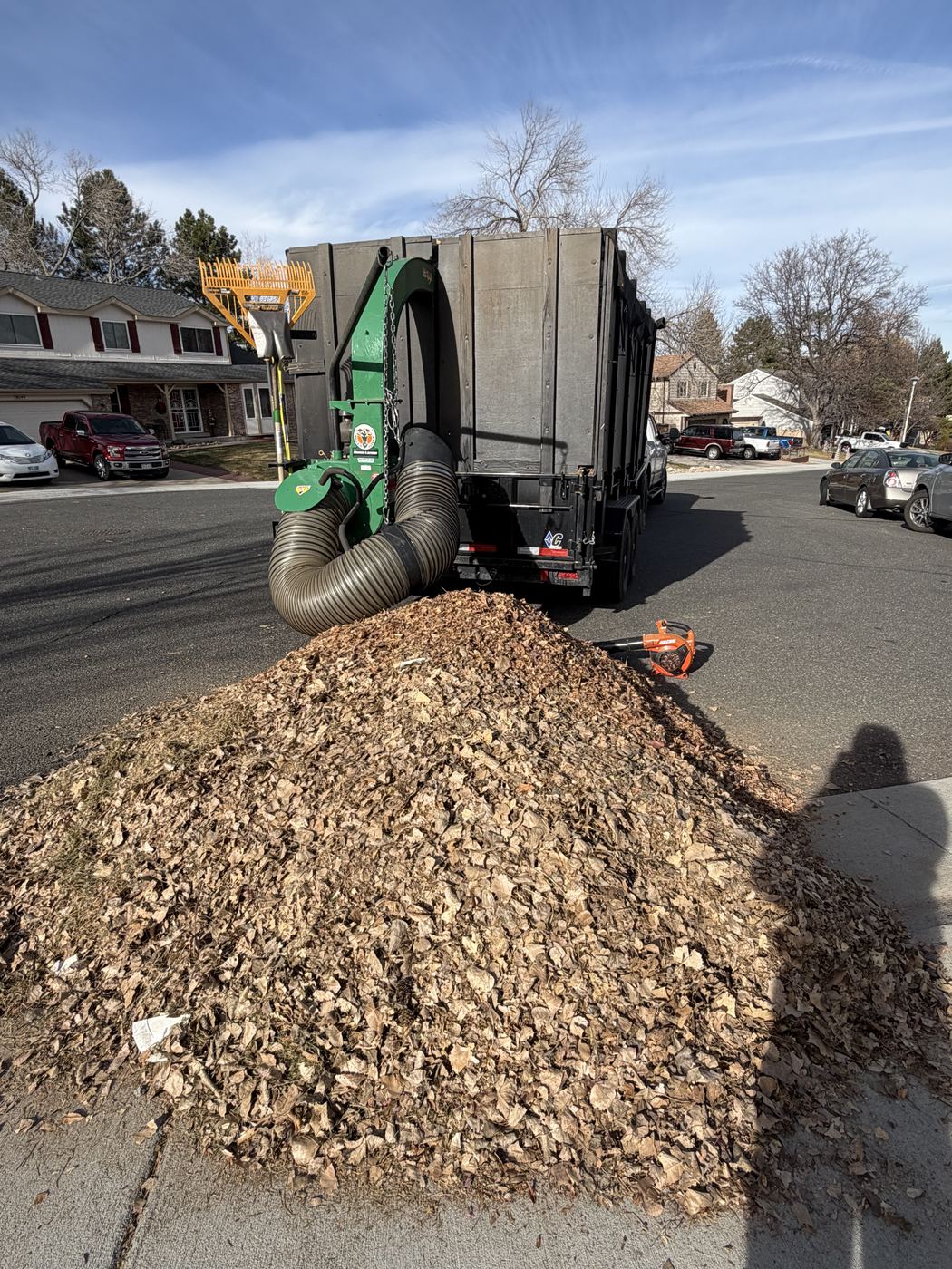 Leaf vacuum truck collecting a large pile of leaves